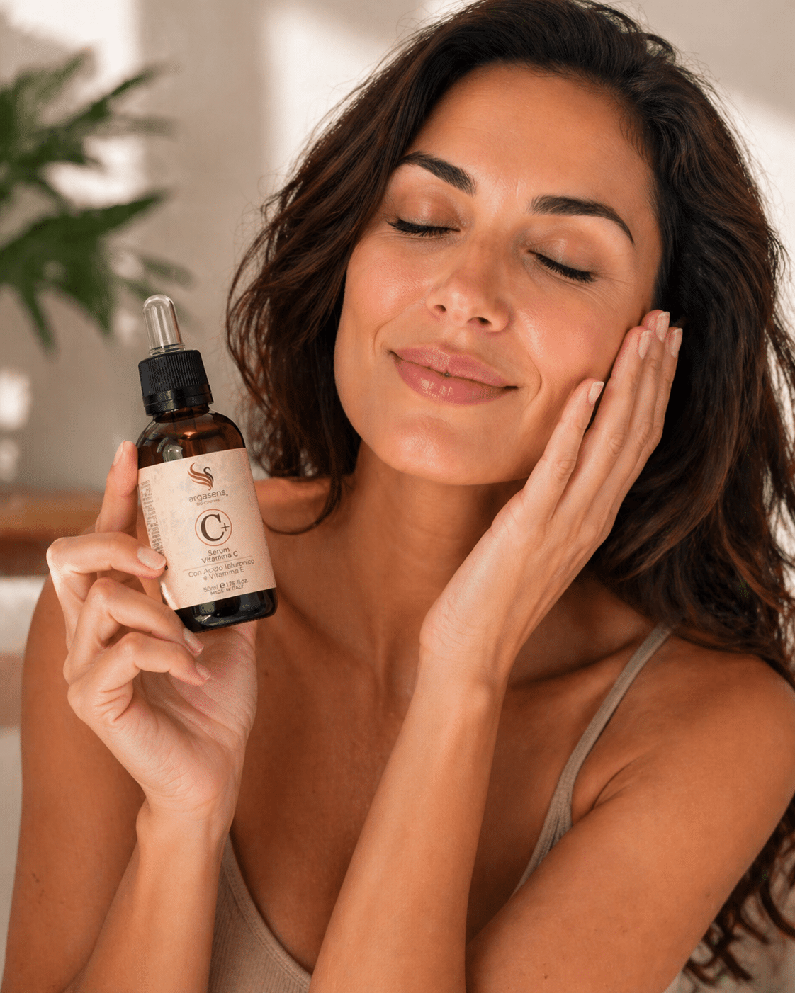 argasens siero vitamina c da 50 ml con donna Donna con occhi chiusi che applica il siero vitamina C Argasens sul viso, mostrando una pelle luminosa e idratata